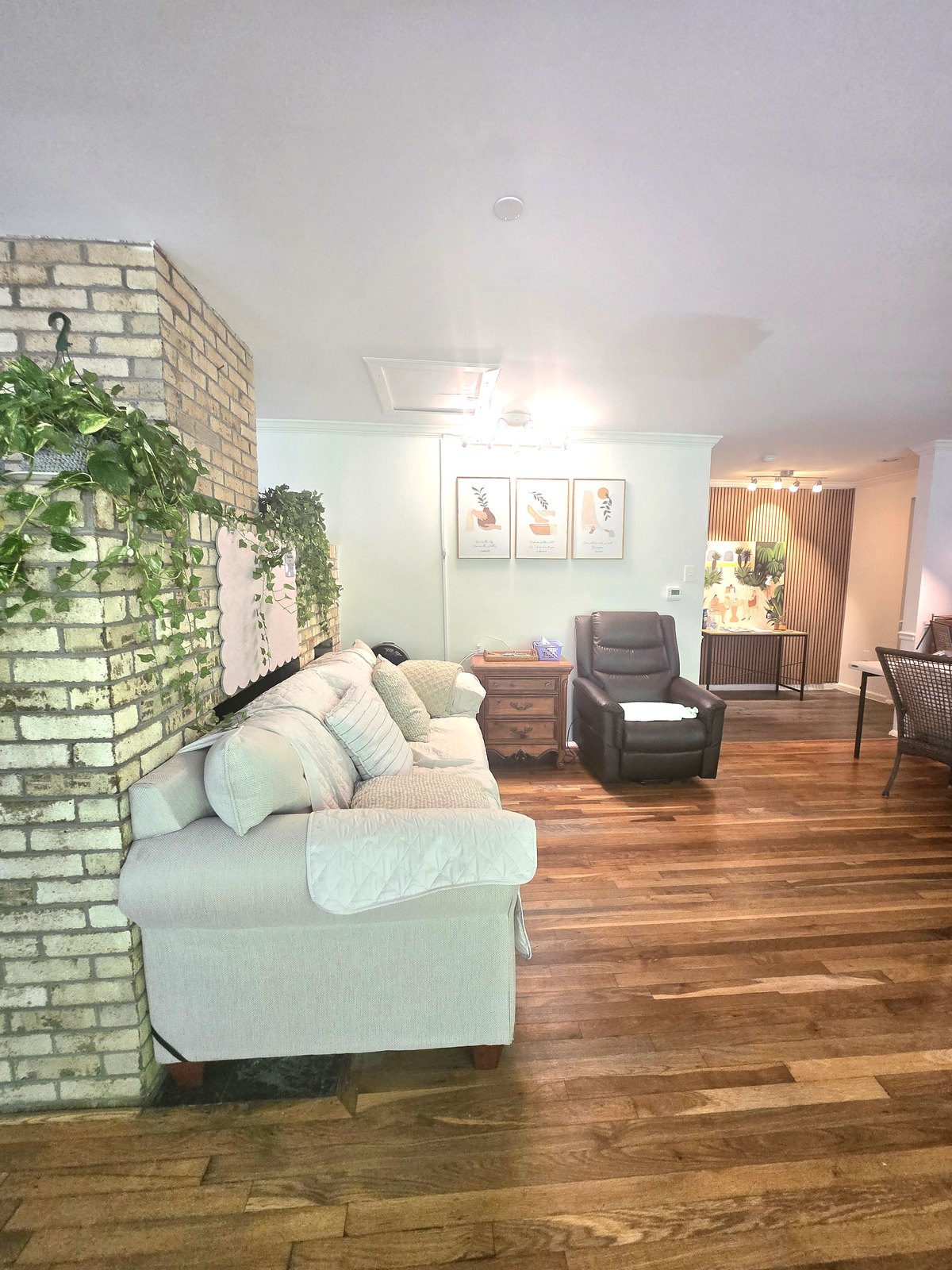 Common room with a brick wall, a sofa and a recliner
